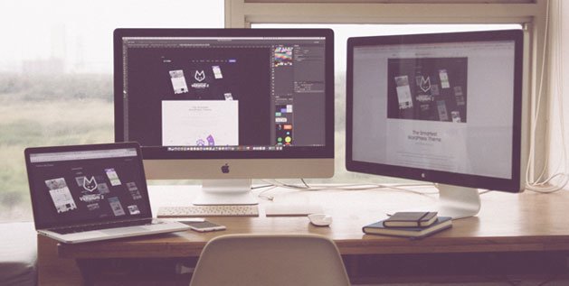 A Photo of a Desk with two computer screens and a laptop showing a website with github logo